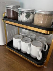 a shelf with four coffee cups on it at Bunga Home with swimming pool access in Lahad Datu