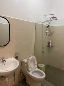 a bathroom with a sink and a toilet and a mirror at Bunga Home with swimming pool access in Lahad Datu +8 photos