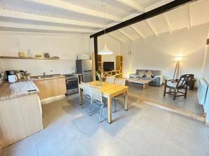 a kitchen and living room with a table and a couch at Los Coirones 1 - Cabaña con jardin in Dina Huapi