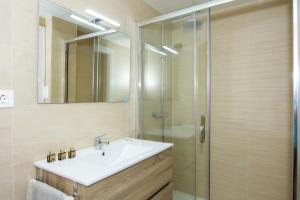 Un baño con lavabo y ducha de cristal. en Águilas Centro Playa La Colonia, en Águilas 33 fotos más