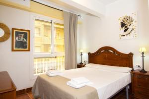 Un dormitorio con una cama con sábanas blancas y una ventana. en Águilas Centro Playa La Colonia, en Águilas