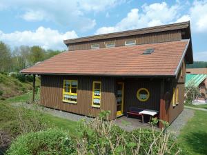 a small house with yellow windows and a roof at Ferienhaus Nr 11B2, Feriendorf Hagbügerl, Bayr Wald in Waldmünchen