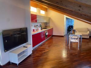 a living room with a large television and a kitchen at La Mansarda di Pinocchio e dei Lego in Bologna