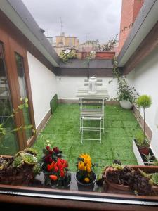 a patio with a table and flowers on a balcony at La Mansarda di Pinocchio e dei Lego in Bologna