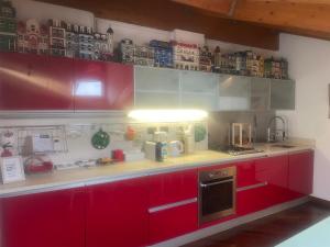 a kitchen with red cabinets and a counter with appliances at La Mansarda di Pinocchio e dei Lego in Bologna +4 photos