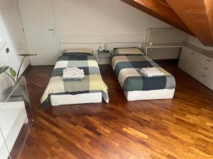 two beds in a room with wood floors at La Mansarda di Pinocchio e dei Lego in Bologna