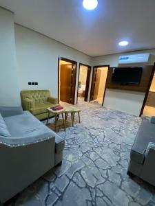 a living room with a couch and a tv at غزالي سويتس ghzali suites in Al Madinah