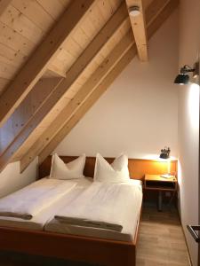 a bed with white sheets and pillows in a room at Schöne Dachwohnung mit 2 Schlafzimmern im Zentrum von Schwarzenberg - Erzgebirge in Schwarzenberg (Erzgebirge)