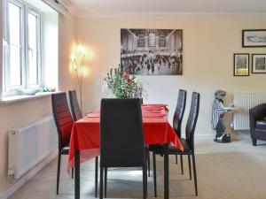 a dining room with a red table and chairs at Elizabeth House in Bampton