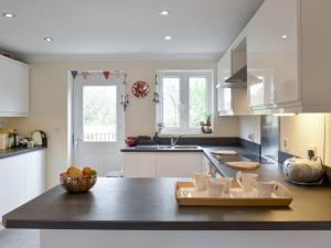 a kitchen with a counter with a bowl of fruit on it at Elizabeth House in Bampton +11 photos