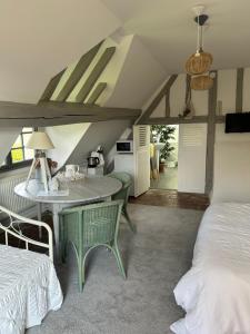 a bedroom with a table and chairs and a bed at La Vigne in Saint-Jean-de-Rebervilliers