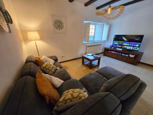 a living room with a couch and a flat screen tv at Quinta do Rio Alva and Glamping Lodges in Mouronho