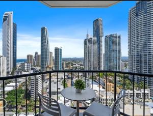 un balcone con tavolo, sedie e vista sulla città di Mantra on View Lvl 20 a Gold Coast