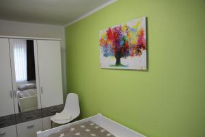 a bathroom with a painting of a tree on the wall at Wohnung Julius 2 in Sankt Andreasberg +7 photos