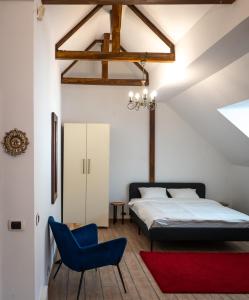 a bedroom with a bed and a blue chair at Villa ANMA in Bucharest