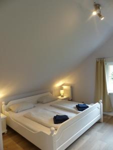 a white bed in a room with a window at Ferienhaus Sonnenblick in Walsrode