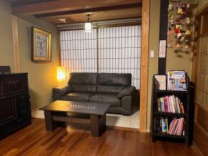 a living room with a leather couch and a coffee table at Kiyomizu Machiya Inn in Kyoto