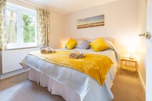 a bedroom with a large bed with towels on it at Brackenhurst Cottage by Big Skies Cottages in West Runton