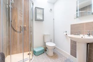 a bathroom with a shower and a toilet and a sink at Brackenhurst Cottage by Big Skies Cottages in West Runton +15 photos