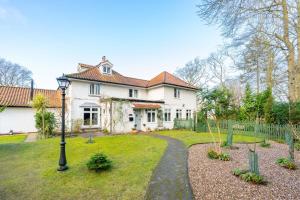 a large white house with a pathway in the yard at Brackenhurst Cottage by Big Skies Cottages in West Runton