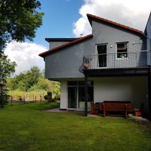 a house with a deck and a bench in the yard at Ferienhaus Sonnenaufgang in Walsrode +10 photos