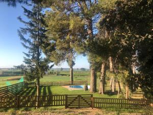 a fence with a pool in a field with trees at Casa rural Cal Dalfo in Almenar