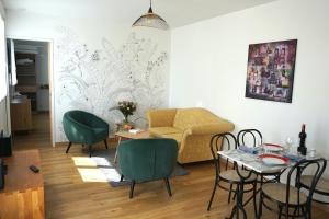 a living room with a couch and a table and chairs at Gîte Côte d'Emeraude in Quévert