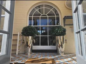 a front door of a house with two potted plants at Queen Anne Cottage in Guildford