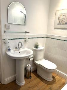 a white bathroom with a toilet and a sink at Rose cottage on the peaceful solway coast in Port Carlisle +13 photos