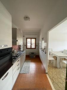 a kitchen with white cabinets and a table in it at Casa Toledo in Torvaianica
