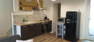 a kitchen with a black refrigerator and a microwave at Le petit coin d'Ina in Coulanges-la-Vineuse