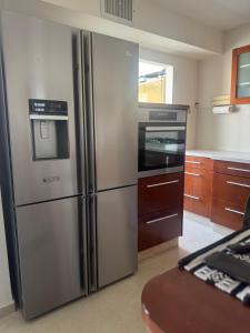 Una cocina con refrigerador de acero inoxidable y estufa. en דירת הים האדום, en Eilat 10 fotos más