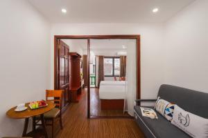 a living room with a couch and a bedroom at ELC Da Lat Apartment in Da Lat