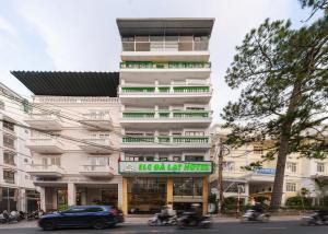 a tall white building with a sign in front of it at ELC Da Lat Apartment in Da Lat