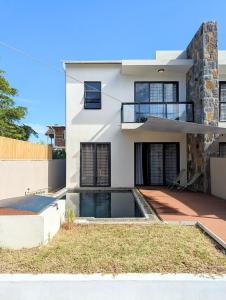 a house with a swimming pool in front of it at Jabali in Roches Noires