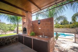 a brick kitchen with a sink and a swimming pool at Cubo's Finca La Sierra in Alhaurín el Grande