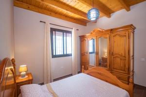 a bedroom with a wooden cabinet and a bed at Cubo's Finca La Sierra in Alhaurín el Grande