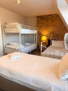 a room with two bunk beds and a brick wall at The Boho - 4 min walk to beach & town in Bournemouth