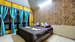 a bedroom with a large bed with blue curtains at Elephant House - Boutique Hostel & CoWork in Méribel Village