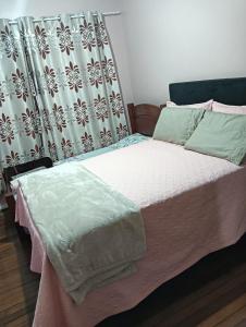 een bed in een slaapkamer met een gordijn bij Casa Com 2 quartos, Garagem Ar tv in Foz do Iguaçu