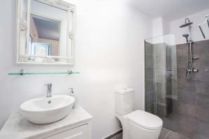 une salle de bain avec un lavabo, des toilettes et un miroir dans l'établissement Jasmine Suites Poolhouse Rhodos, à Koskinou