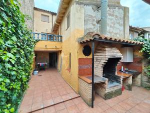 an outdoor pizza oven in a courtyard of a house at CASA RURAL EL CAIDERÓN in Ambel