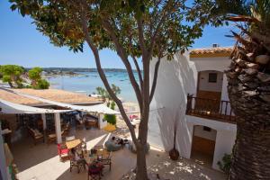 a view of a patio with tables and a tree at Hostal la Savina in La Savina +37 photos