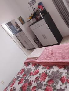 a kitchen with a bed with a flowered bed skirt at Quarto casal ARENA OPUS in São José +10 photos