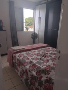 a bedroom with a bed and a dog looking out the window at Quarto casal ARENA OPUS in São José