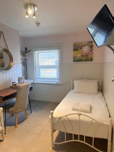 a bedroom with a bed and a desk and a desk at The Boho - 4 min walk to beach & town in Bournemouth