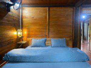 a bedroom with a bed with a wooden wall at Hà Giang Lake View House in Lan Hung