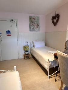 a bedroom with a bed and a table and a heart picture at The Boho - 4 min walk to beach & town in Bournemouth