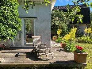 a chair sitting on a wooden deck with flowers at Villa Betty in Visby