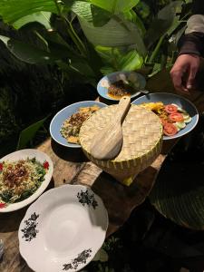 a table topped with plates of food and a bowl at Opik Homestay Tete Batu in Tetebatu